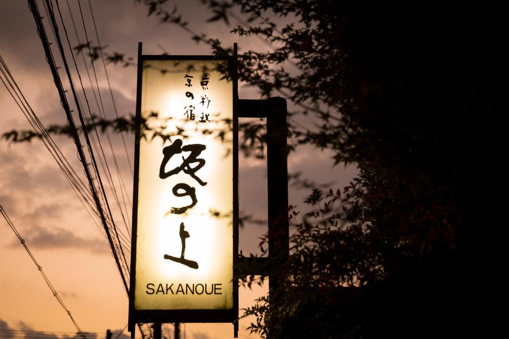 ein Schild für ein saakyuarmaarma Restaurant mit Sonnenuntergang in der Unterkunft Kyoto Ryokan SAKANOUE in Kyoto