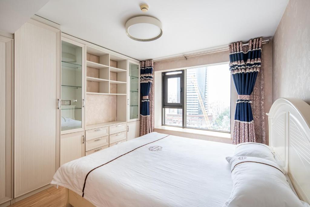 a bedroom with a large bed and a window at Tianjin Mengxiangjia Loft Hotel Apartment in Tianjin
