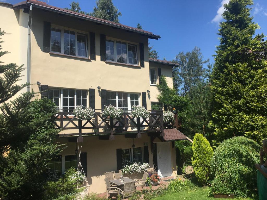 una grande casa bianca con balcone e alberi di Willa Szyszka a Karpacz