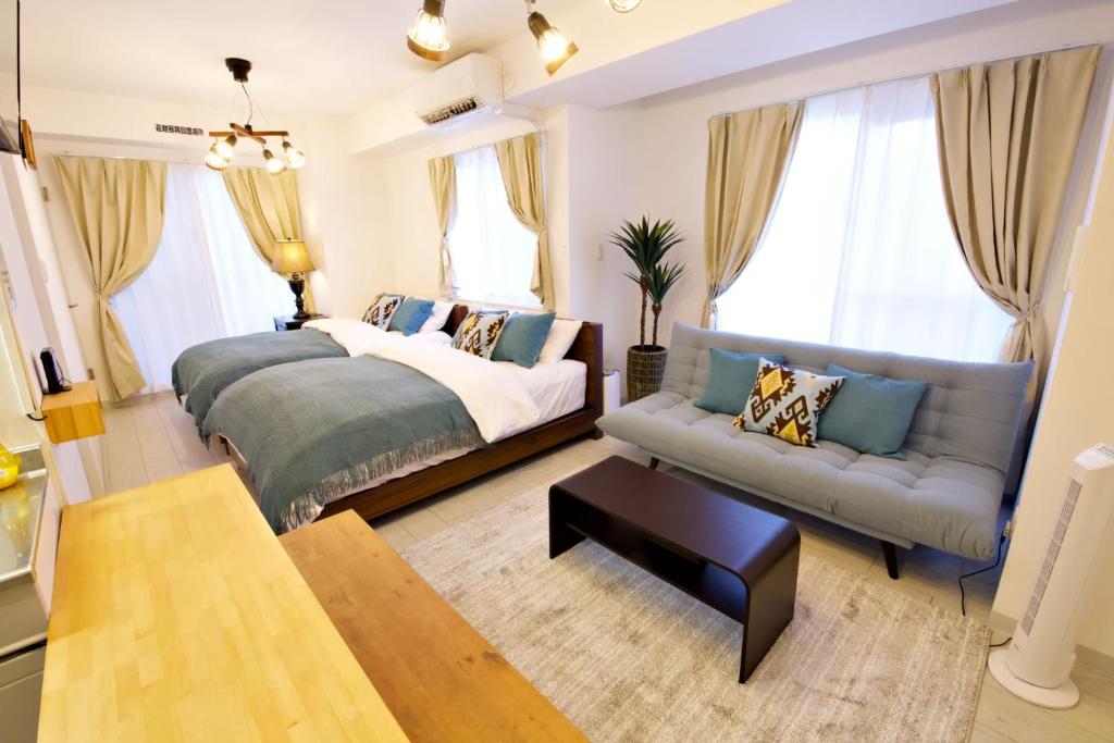 a bedroom with a bed and a couch at K-HOUSE Naha Maejima in Naha
