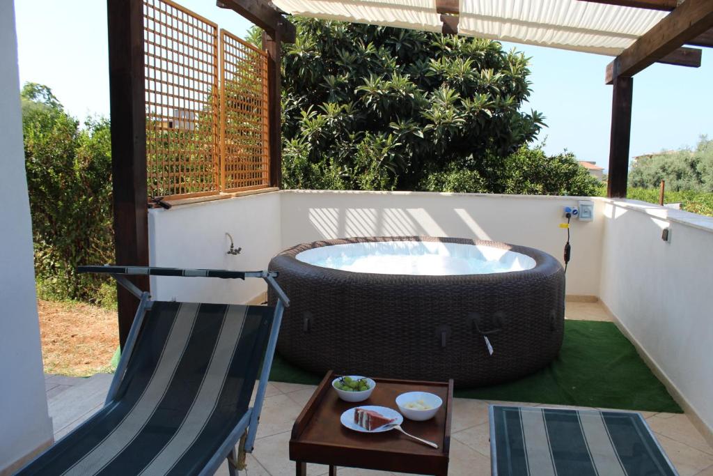 a large tub sitting on a patio with a chair at Dimora Di Campagna in Portella di Mare