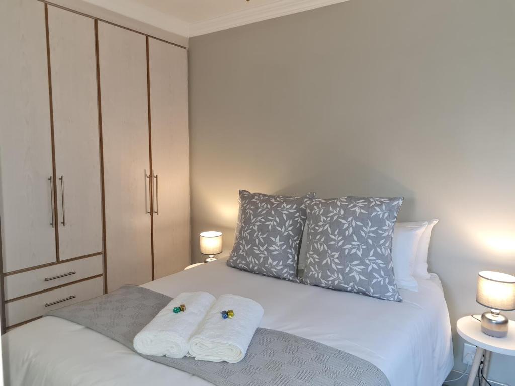 a bedroom with a bed with two towels on it at The Honeycomb in Kimberley