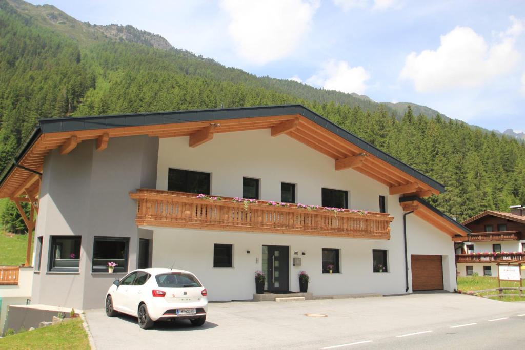 a white car parked in front of a building at Apart Bergglück in Sankt Leonhard im Pitztal