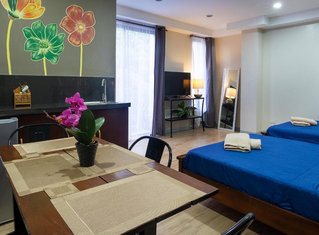 Zimmer mit einem Bett und einem Tisch mit Blumen an der Wand in der Unterkunft Luis miguel's place in Dumaguete