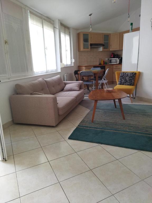 a living room with a couch and a table at Au coeur de Chantilly in Chantilly