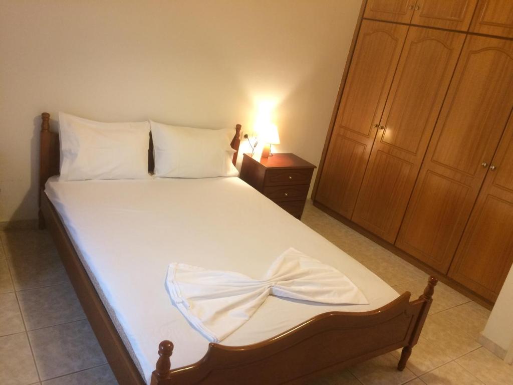 sypialnia z łóżkiem z białą pościelą i szafką nocną w obiekcie Guesthouse "Athina" w mieście Ellinikón
