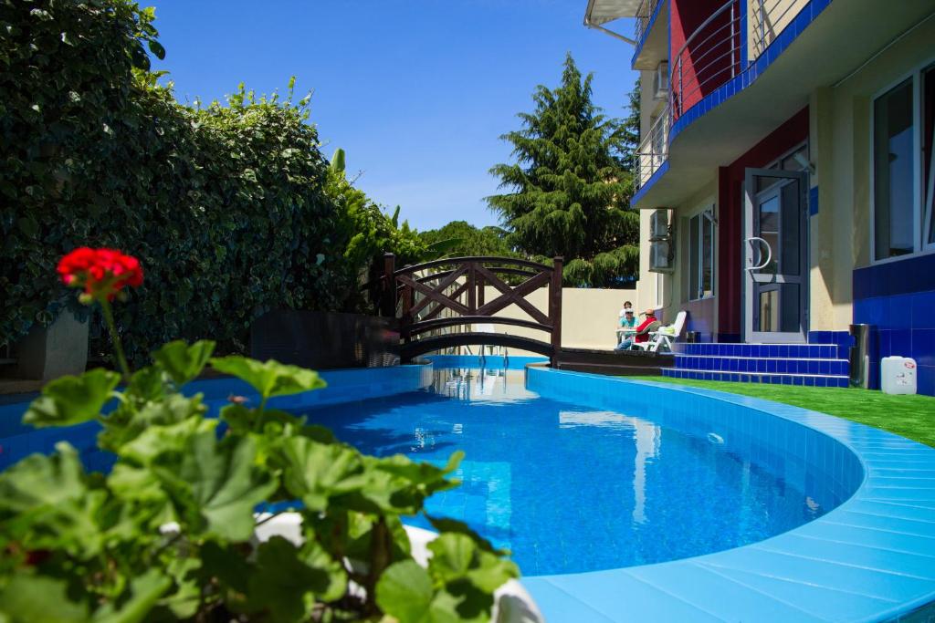 una piscina azul junto a un edificio con puente en Hotel Marmaris, en Adler