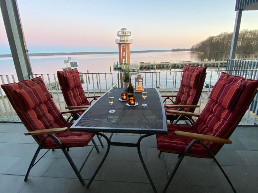 a table and chairs on a balcony with a lighthouse at Weisses Haus Plau in Plau am See