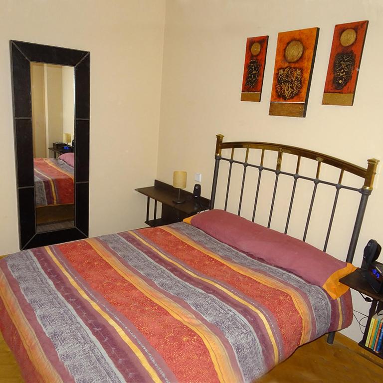 a bedroom with a bed with a colorful blanket at INTRAMUROS alojamiento dentro de la muralla in Ávila
