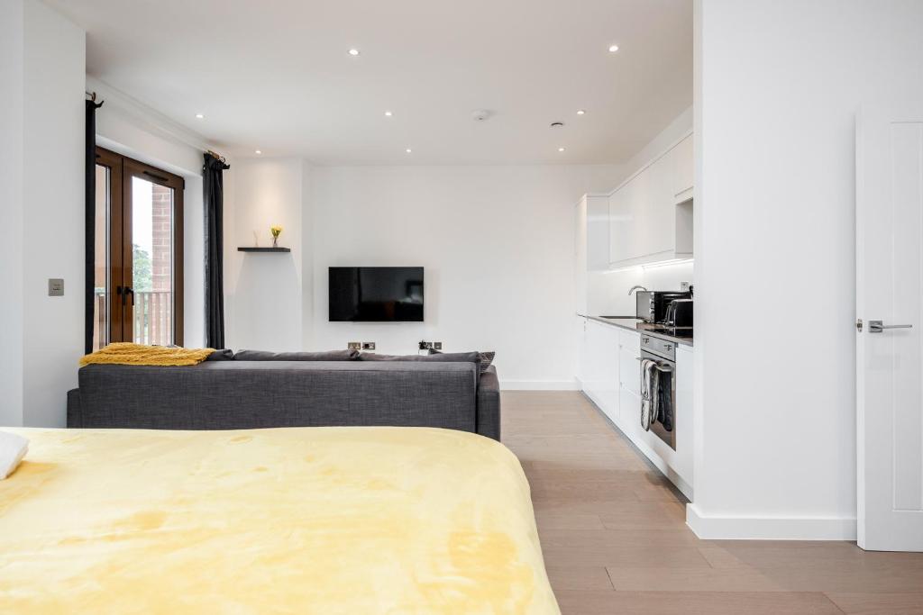 セント・オールバンズにあるLuxury Studio Apartment St Albans - Free Parking with Amaryllis Apartmentsの白いリビングルーム(ソファ付)、キッチンが備わります。