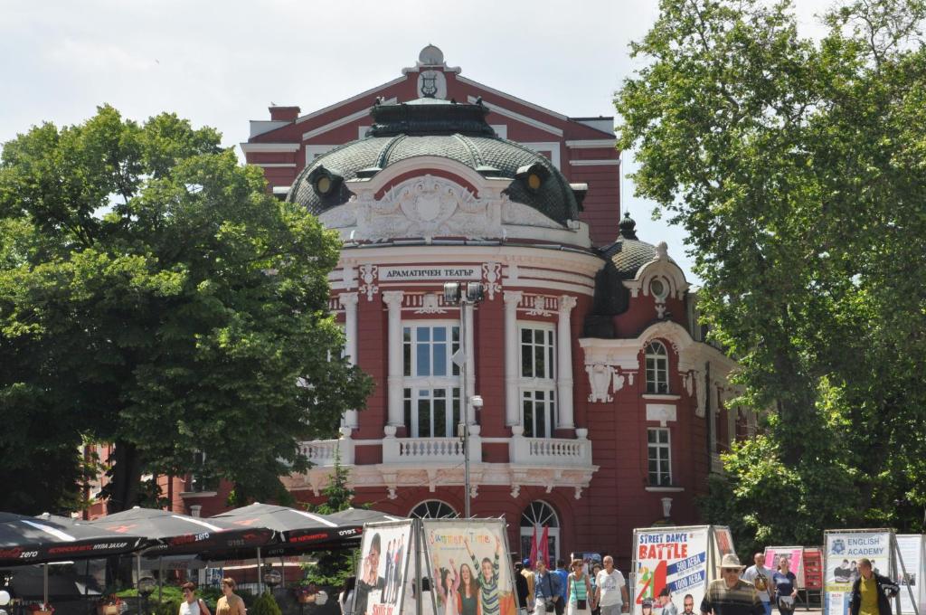 a large red brick building with a clock on it at Arlequin Apartment in Varna City