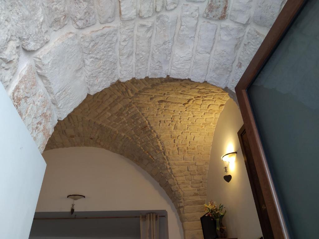 uma arcada num quarto com tecto de tijolos em Soggiornare In Centro em Alberobello