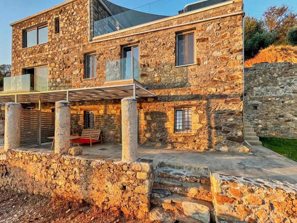 a stone house with a deck on a stone wall at INO III Domus by Amigdalokefali Elafonissi in AmigdhalokeFálion