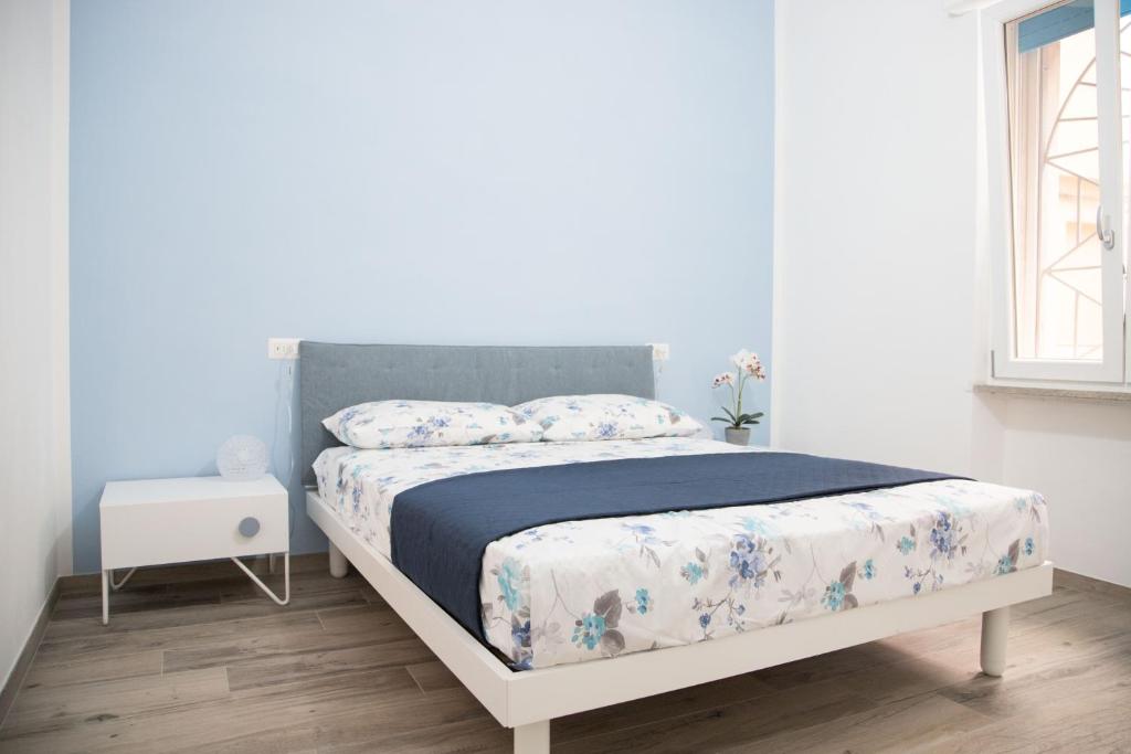 a bedroom with a bed with a blue and white comforter at Appartamento il Mulino in Orbetello