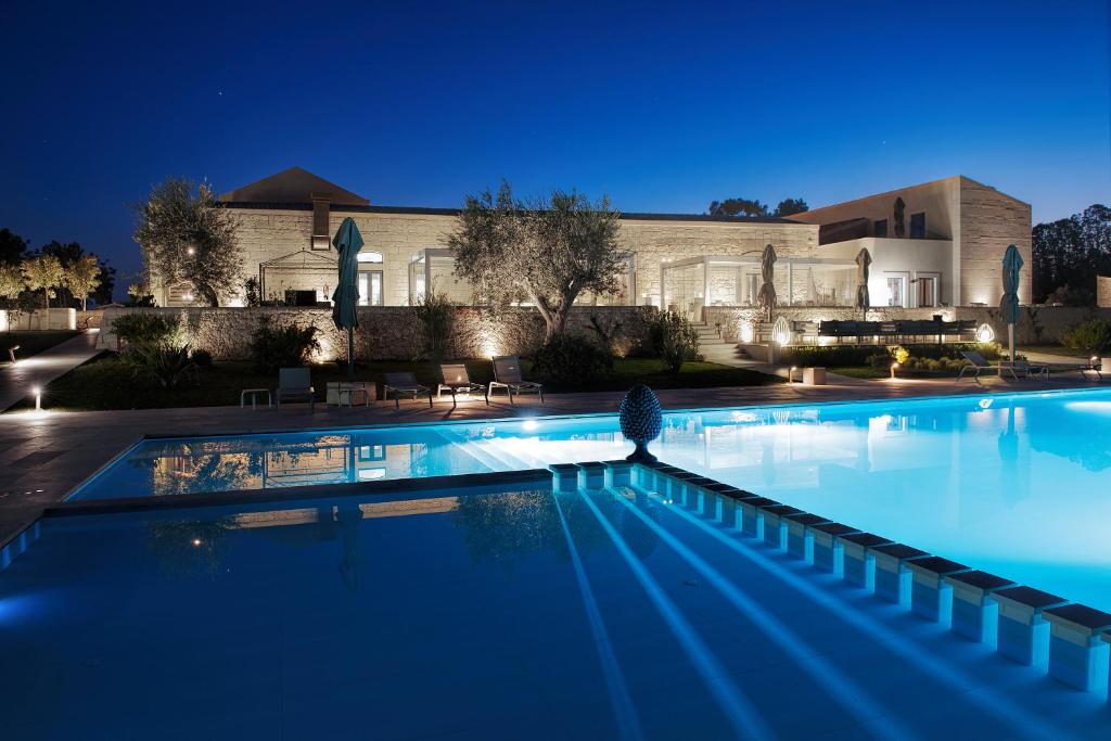 a swimming pool in front of a building at night at Masseria Della Volpe in Casale Modica