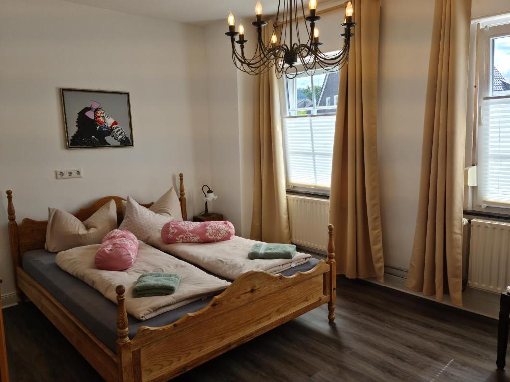 梅舍德的住宿－Pilgrims Gästeapartements，窗户间内的一张带粉红色枕头的床