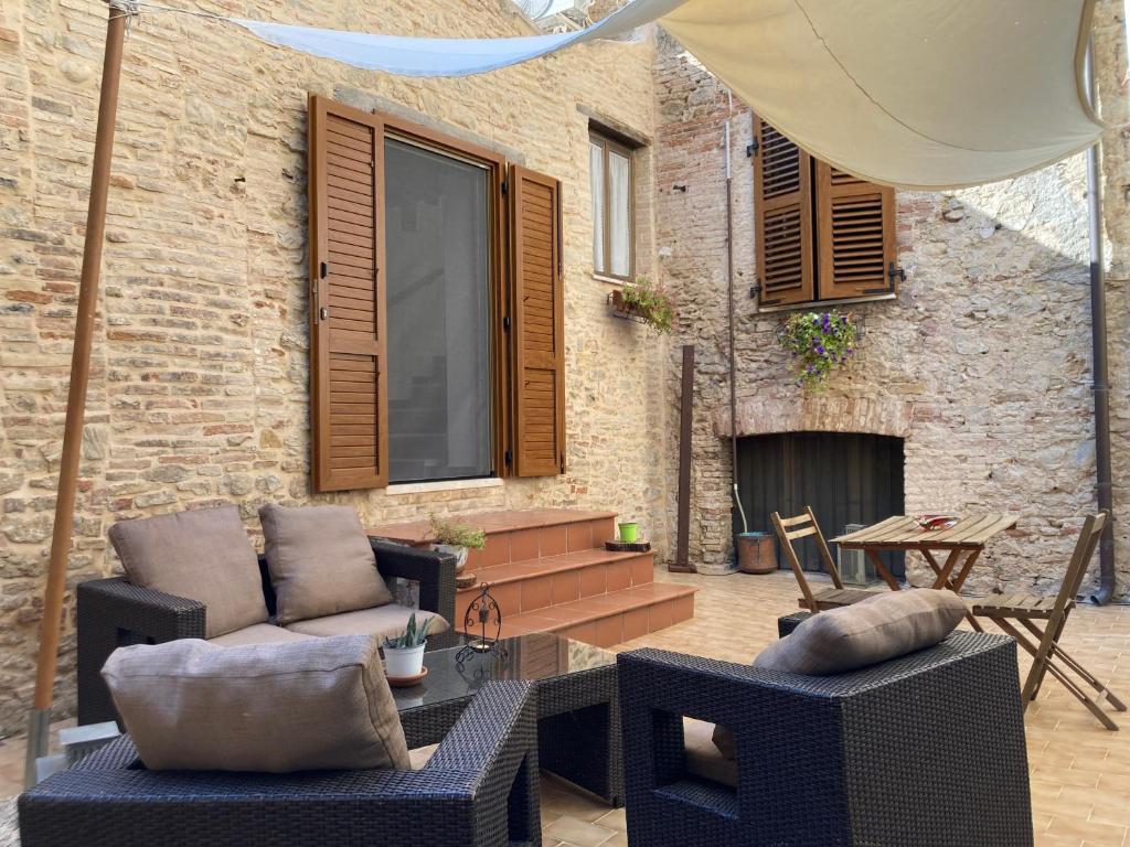un patio con muebles y un edificio de ladrillo con chimenea en Il Patio di Crecchio en Crecchio