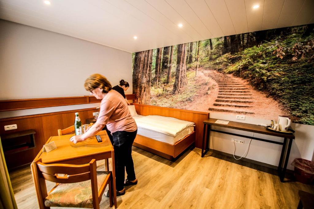 a woman standing at a table in a room at Landhotel am Wenzelbach in Prüm