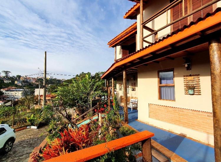 ein Haus mit einer Bank davor in der Unterkunft Pousada Natureza e Arte in Cunha