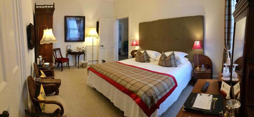 una habitación de hotel con una cama grande y una mesa en The Townhouse en Perth