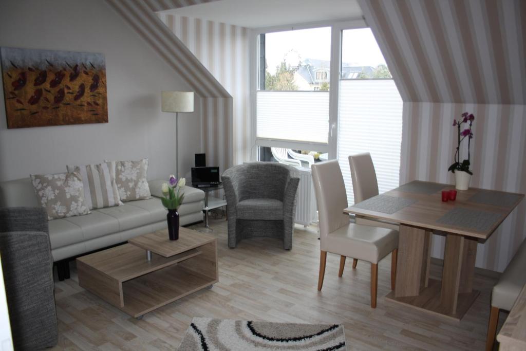 ein Wohnzimmer mit einem Sofa und einem Tisch in der Unterkunft Strandnahe Ferienwohnungen Duhnen inkl Fahrrädern Cuxhaven in Cuxhaven