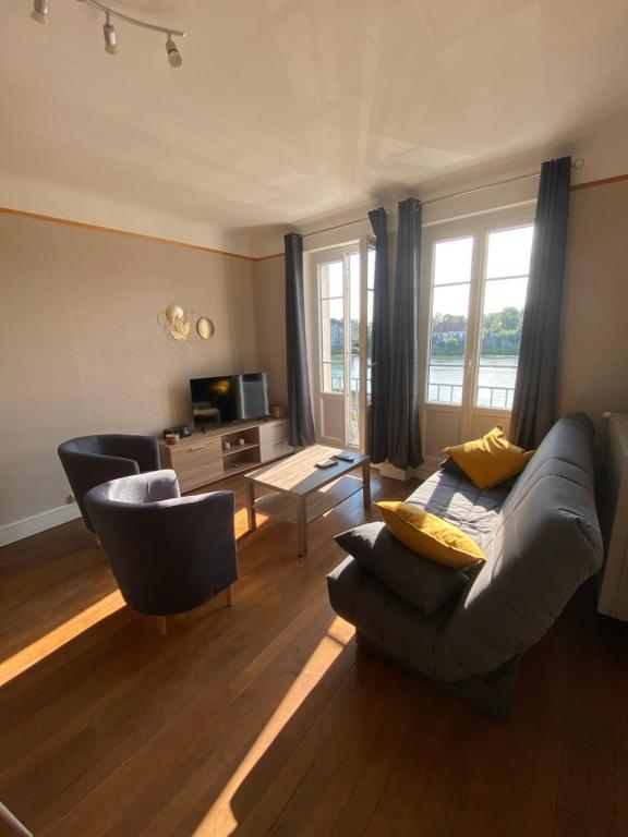 uma sala de estar com um sofá e duas cadeiras em L’appartement de Rose em Seurre