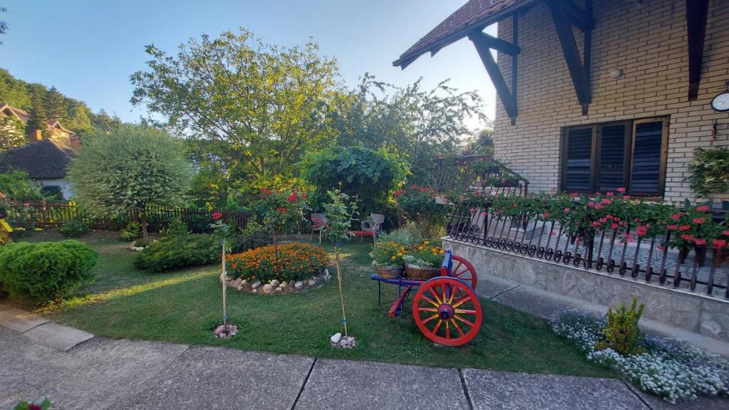 a garden with a red wagon in front of a house at Apartmani Mali Raj Rudnik in Rudnik