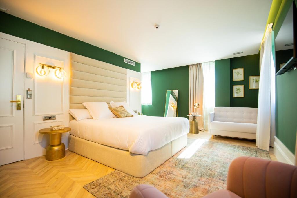 een slaapkamer met een wit bed en een groene muur bij Casa do Estanco in Quiroga