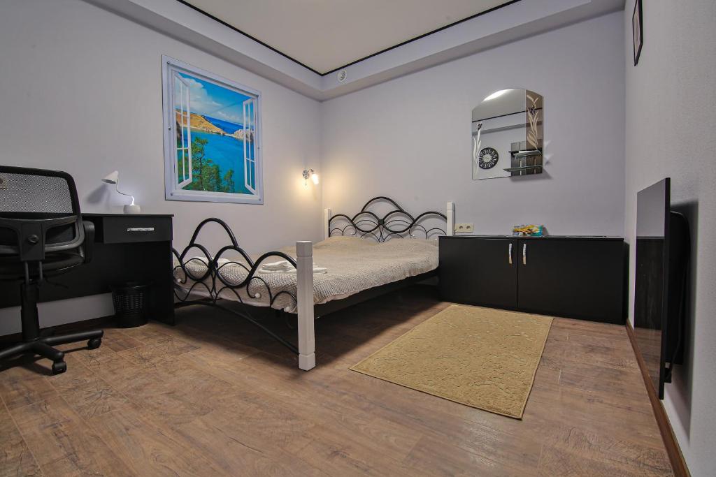a bedroom with a bed and a desk and a television at Battle Mile Hostel in Cherkasy