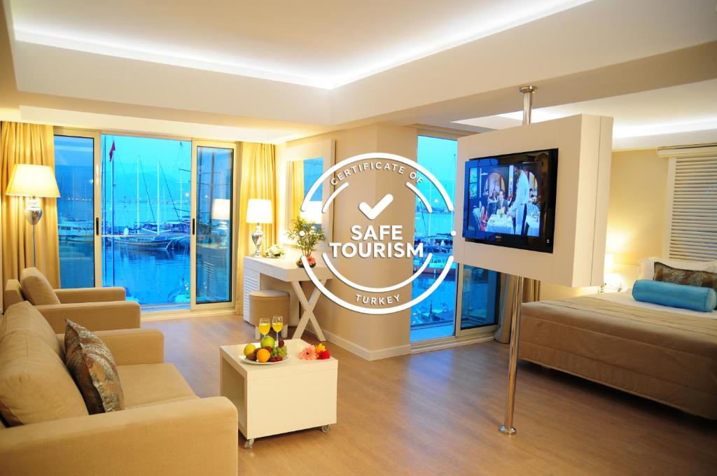 a living room filled with furniture and a tv at Alesta Yacht Hotel in Fethiye