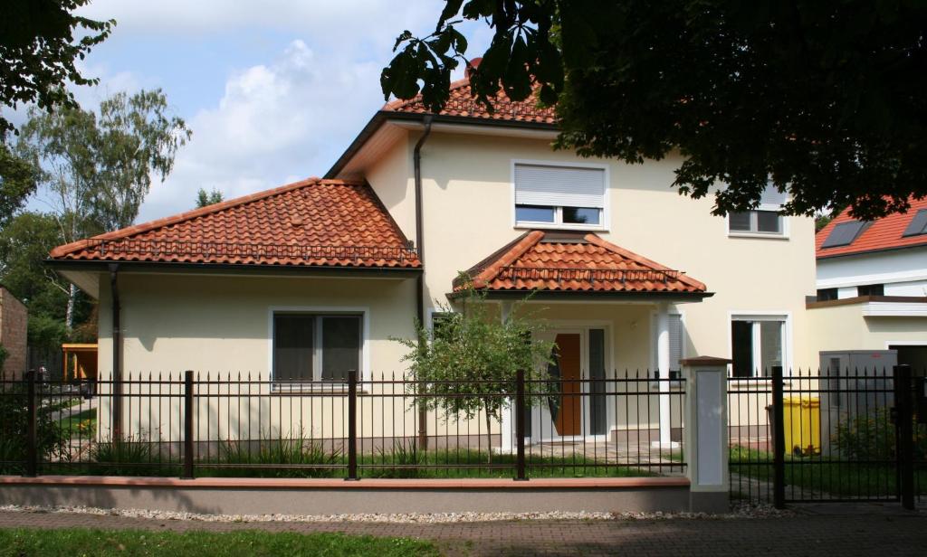ein weißes Haus mit einem schwarzen Zaun in der Unterkunft Business Lounge Potsdam in Potsdam
