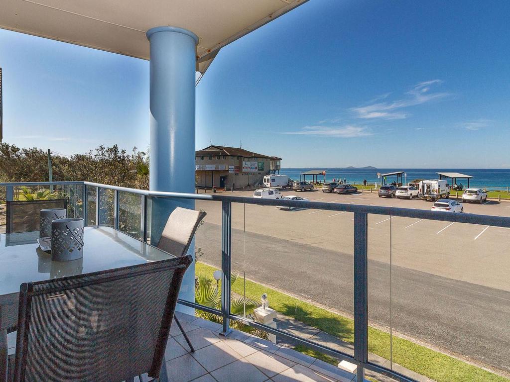 uma varanda com uma mesa e vista para um parque de estacionamento em Nautilus 6 Beach Front Bliss em Hawks Nest