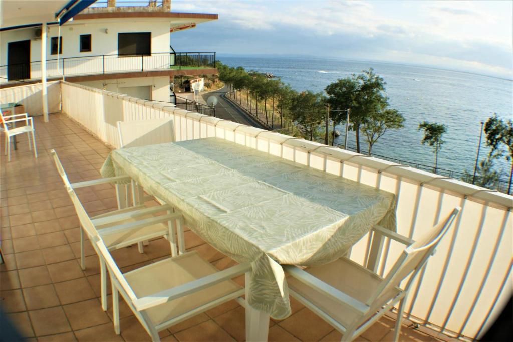 uma mesa e cadeiras numa varanda com o oceano em Bonito apartamento en Roses con vistas al mar em Roses