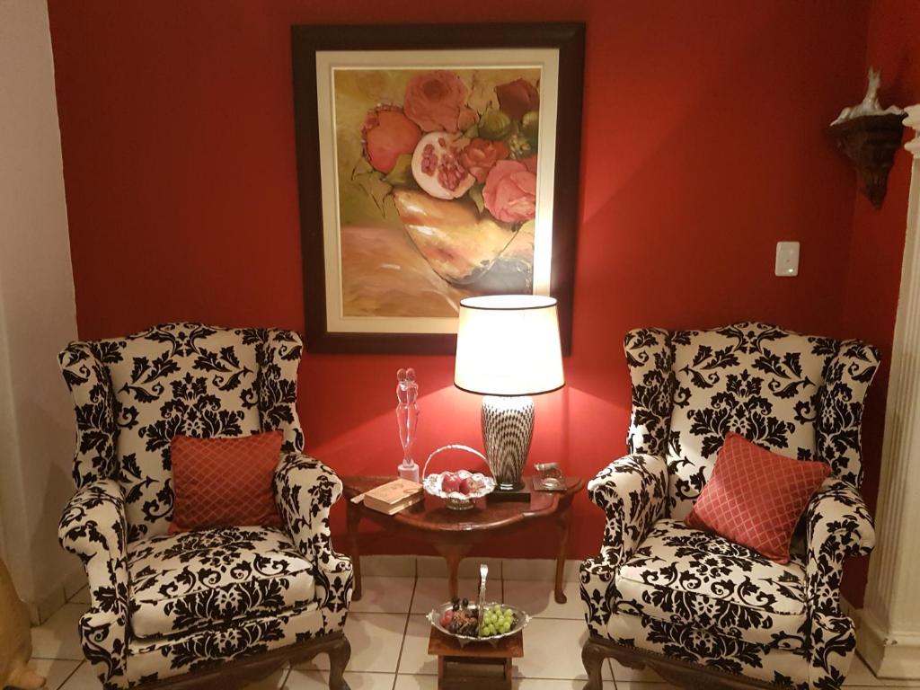 two chairs and a table in a room with a painting at Michael-Angelo guest house in Potchefstroom
