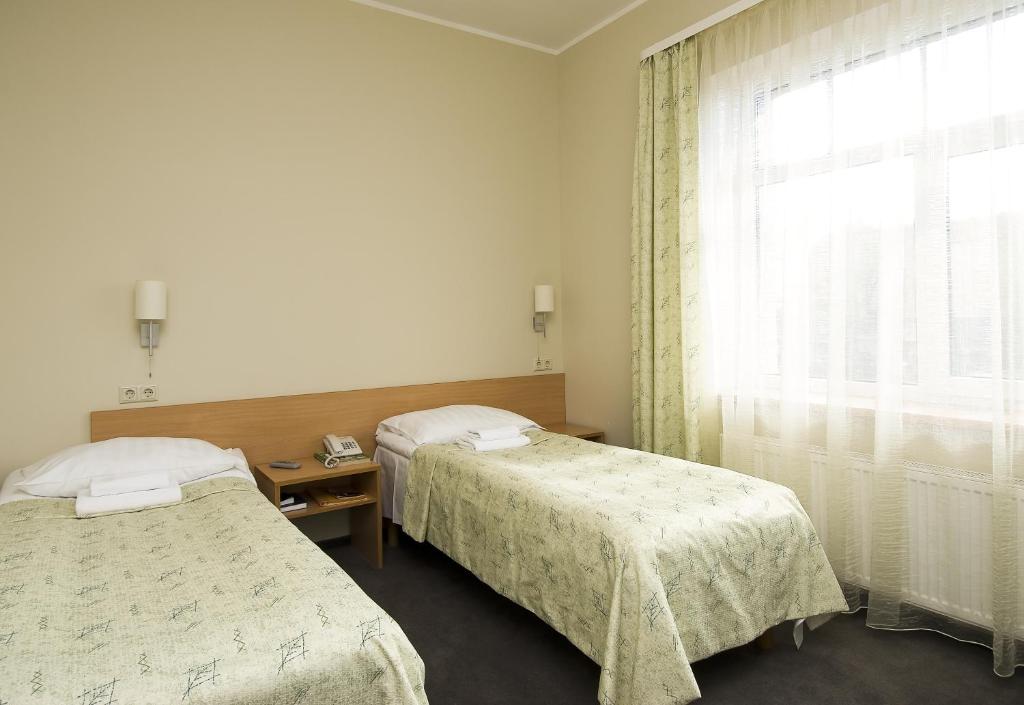 Postel nebo postele na pokoji v ubytování TOSS Hotel