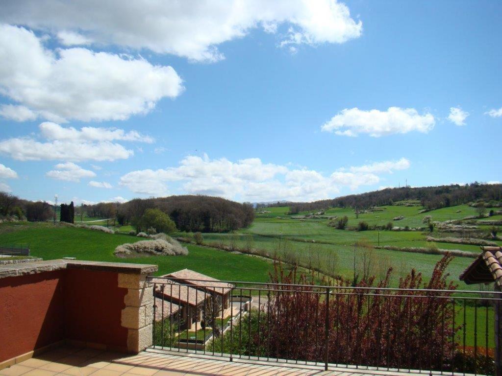 una casa con vistas a un frondoso campo verde. en Can Vilafort en Collsuspina