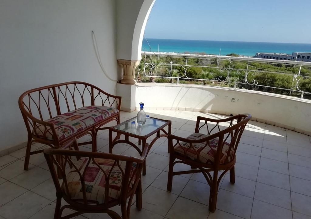 balcone con 2 sedie e tavolo con vista sull'oceano di Azure Residences a Kelibia