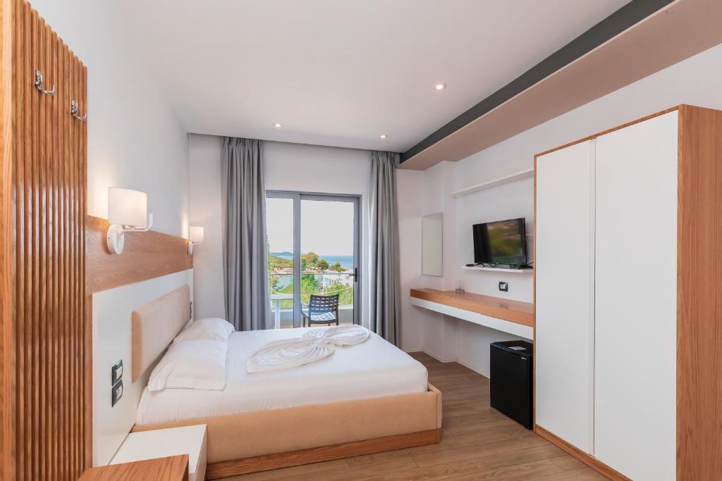 - une chambre d'hôtel avec un lit et un miroir dans l'établissement Ventus Hotel, à Ksamil