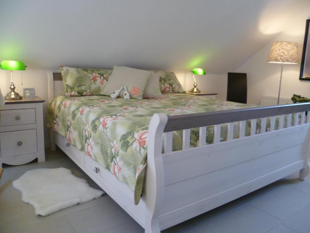 a bedroom with a white bed with flowers on it at Studio SAVOIR & VIVRE Adults Only - Anno 2021 - in Garding