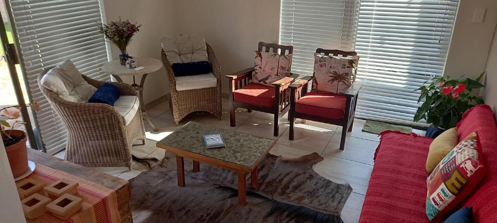 a living room with chairs and a table at Sea Cottage in Mossel Bay