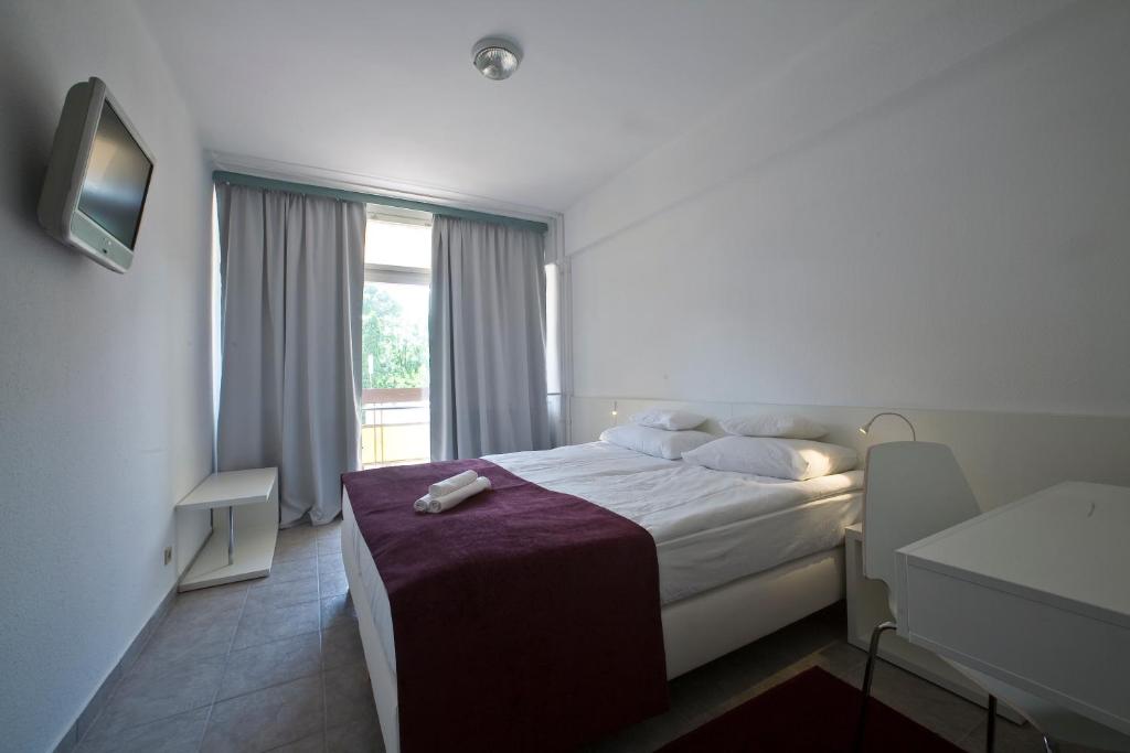 Postel nebo postele na pokoji v ubytování Hotel Holiday Csopak