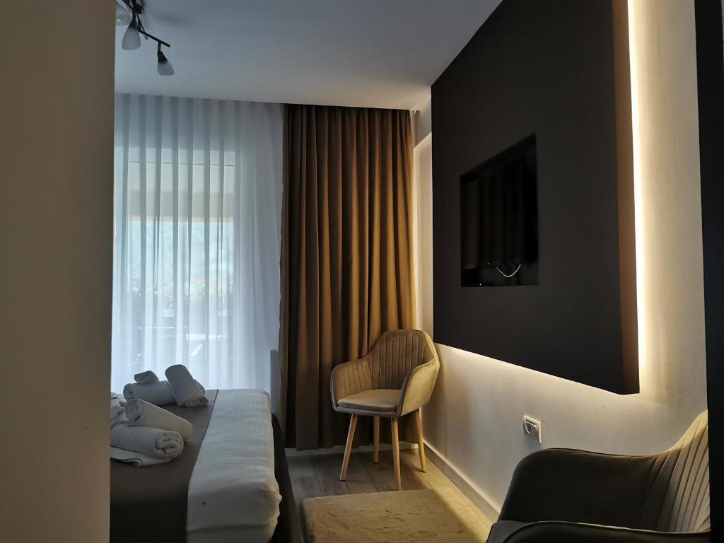 a hotel room with a bed and a chair at Doftana Apartaments in Teşila