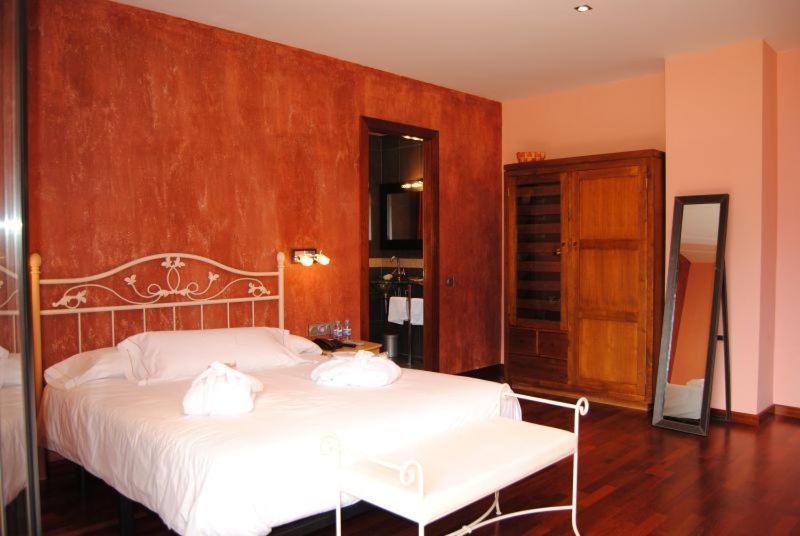 a bedroom with a bed with two pillows on it at Hotel Dom in Organyà