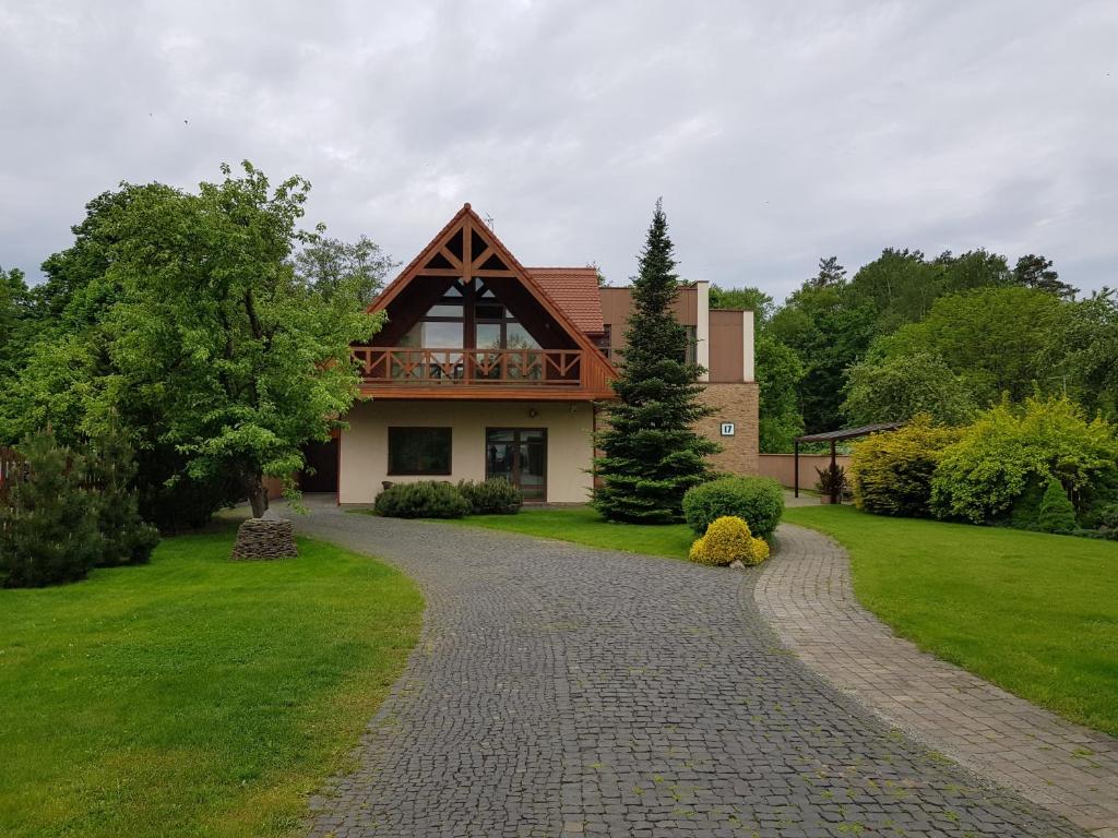 a home with a brick driveway leading to a house at Apartamentai Hunter house in Druskininkai