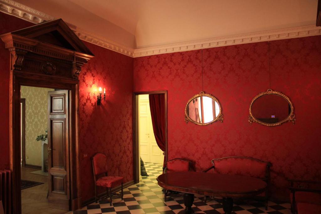 een rode kamer met een tafel en een spiegel bij Dimora Castelli in Chieti