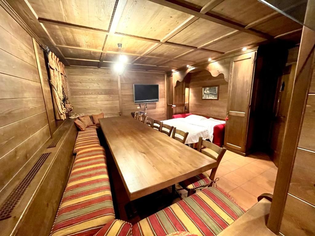 Habitación con mesa de madera y cama en Appartamento Paradiso Cortina, en Cortina dʼAmpezzo