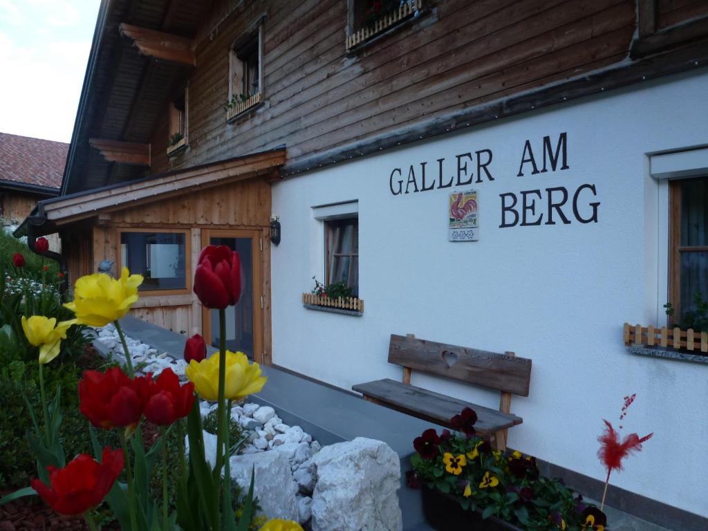 a sign on the side of a building with flowers at Galler am Berg in San Candido
