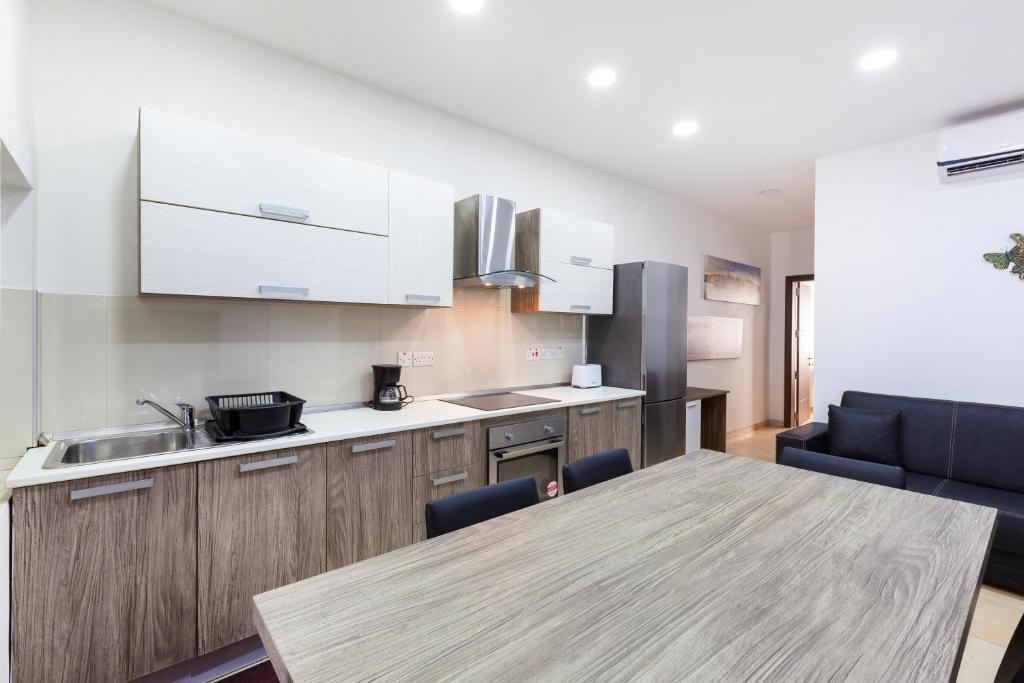 cocina con mesa de madera y encimera en PC3- Centrally Located Apt-Close to University, en Msida