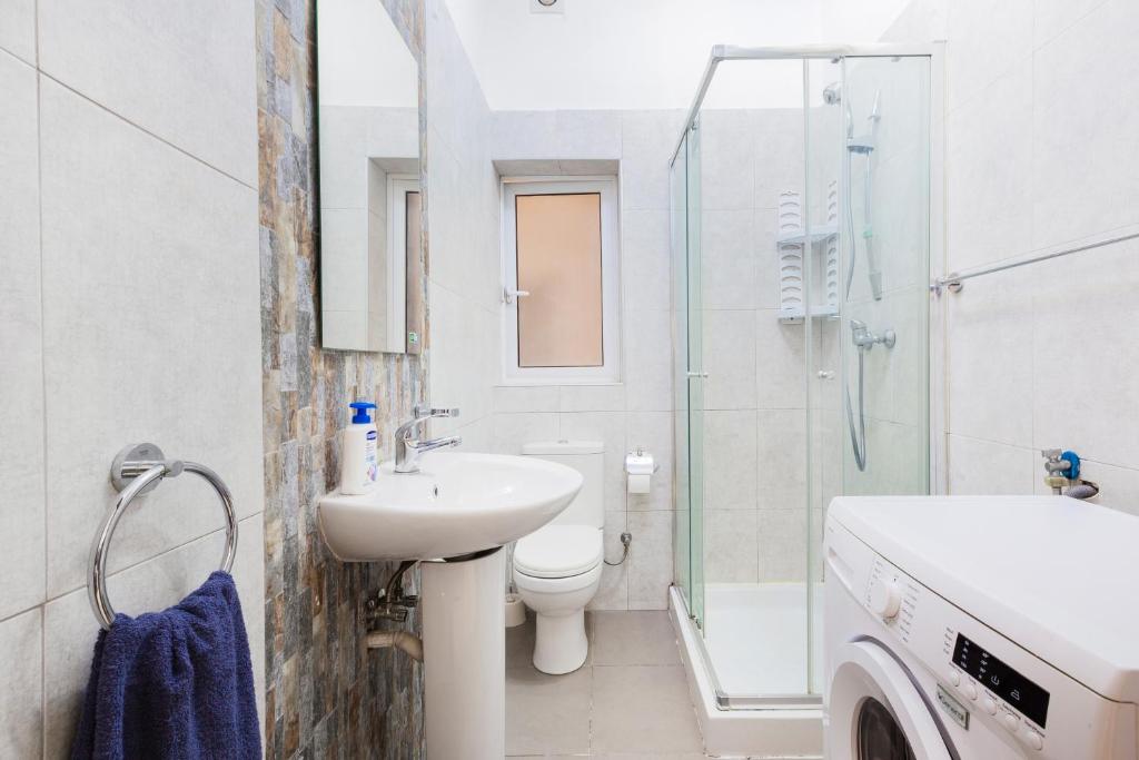 Un baño con lavabo, inodoro y ducha. en PC3- Centrally Located Apt-Close to University, en Msida
