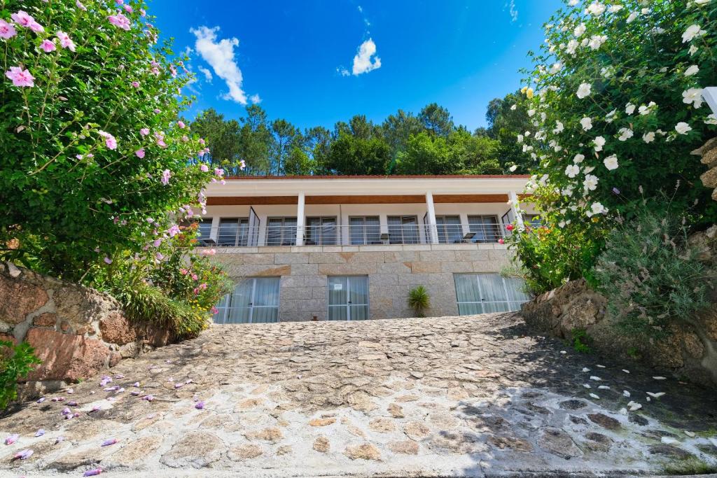 un edificio con flores al lado de una carretera en Casa do Lago - Geres, en Gerês